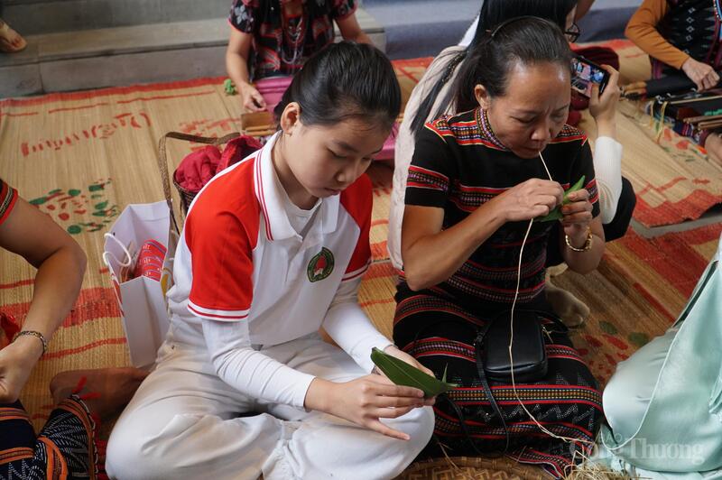 Các em nhỏ trải nghiệm gói bánh của đồng bào Cơ Tu