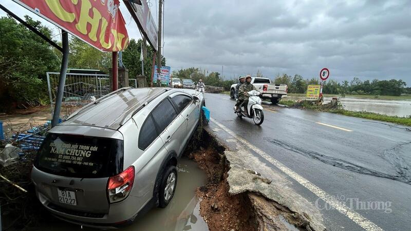 Một chiếc ô tô bị nước lũ cuốn trôi và mắc lại trước nhà dân
