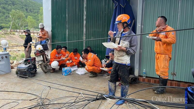 Bữa cơm trưa tranh thủ của các công nhân điện lực. Ảnh: Lê Sơn.