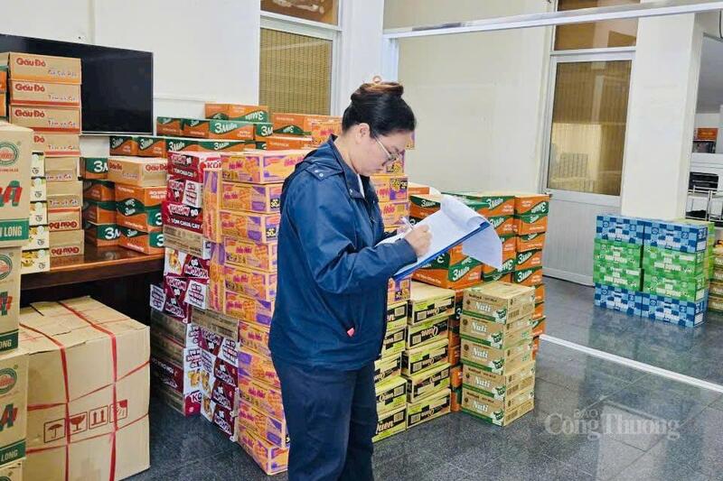 Cán bộ đội Quản lý thị trường số 11 kiểm đếm số lượng nhu yếu phẩm được tiếp nhận để gửi đến bà con vùng lũ. Ảnh: Hiền Mai