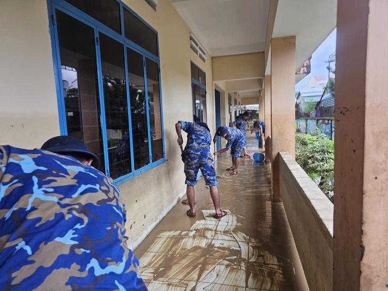 Lực lượng Cảnh sát biển hỗ trợ người dân vệ sinh môi trường khi nước rút. Ảnh: Xuân Ngọc.