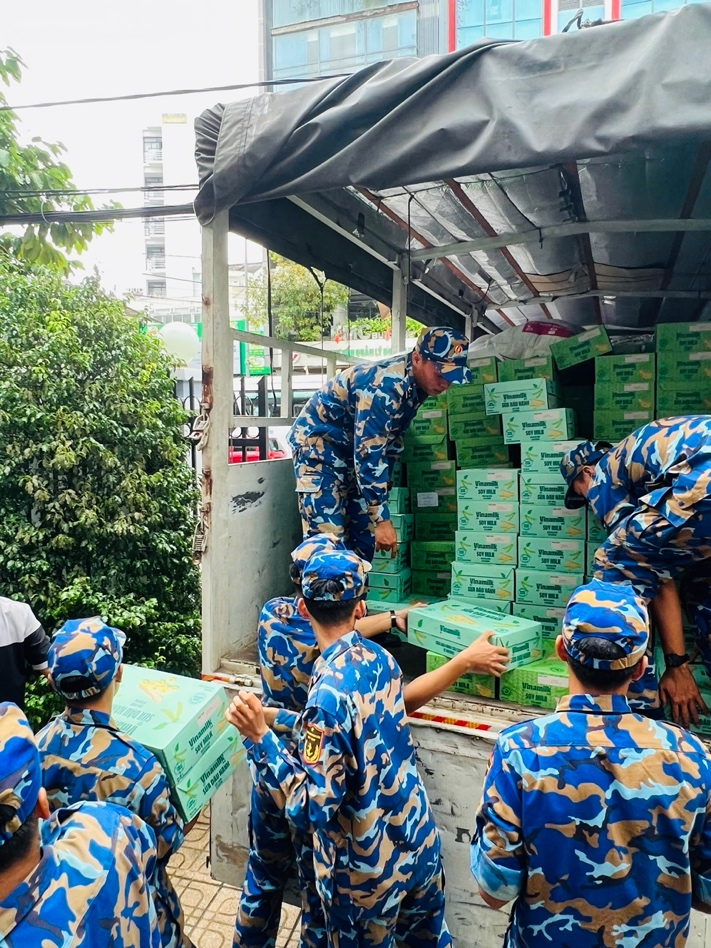 Các chiến sĩ Trung tâm Huấn luyện Vùng 4 Hải quân đang chuyền nhau các sản phẩm dinh dưỡng Vinamilk, sẵn sàng vận chuyển đến tận tay bà con vùng lũ. Ảnh: Vi Nam