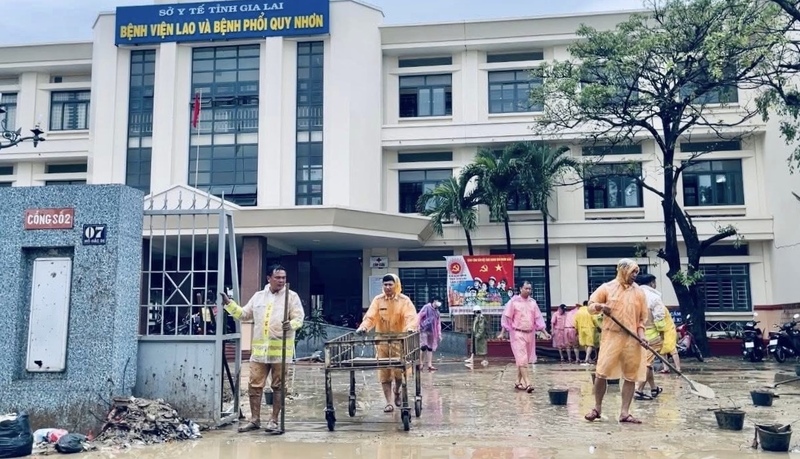 Αστυνομικοί της τροχαίας της αστυνομίας της πόλης Χο Τσι Μινχ καθαρίζουν τη λάσπη στο Νοσοκομείο Φυματίωσης και Πνευμονολογίας Κουί Νον.