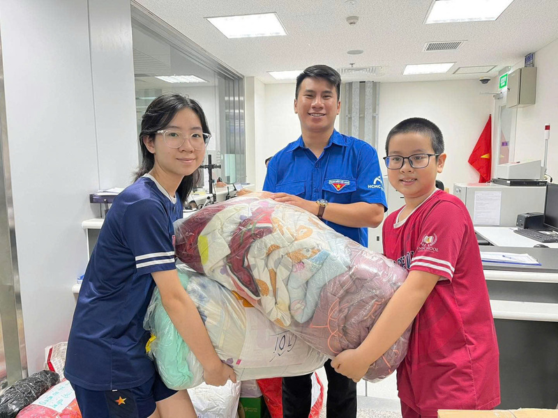 Những em nhỏ theo bố mẹ đến các điểm tập kết nhận hàng để ủng hộ cho bà con miền Trung. Ảnh: Thông tin Chính phủ