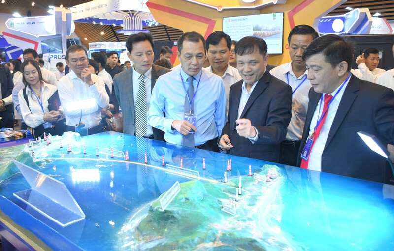 Ông Đặng Hoàng An - Chủ tịch Hội đồng Thành viên EVN và các đại biểu tham dự hội nghị (thứ ba từ phải sang), cùng các đại biểu tham quan sa bàn giới thiệu mô hình truyền tải điện ra đặc khu Phú Quốc tại Techshow 2025. Ảnh: Minh Khuê.