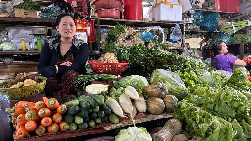 ពាណិជ្ជករ Nguyen Thi Ngoc Huyen ចែករំលែកអំពីតម្លៃបន្លែជាមួយអ្នកយកព័ត៌មានពីកាសែត Cong Thuong។ រូបថត៖ វូឡុង