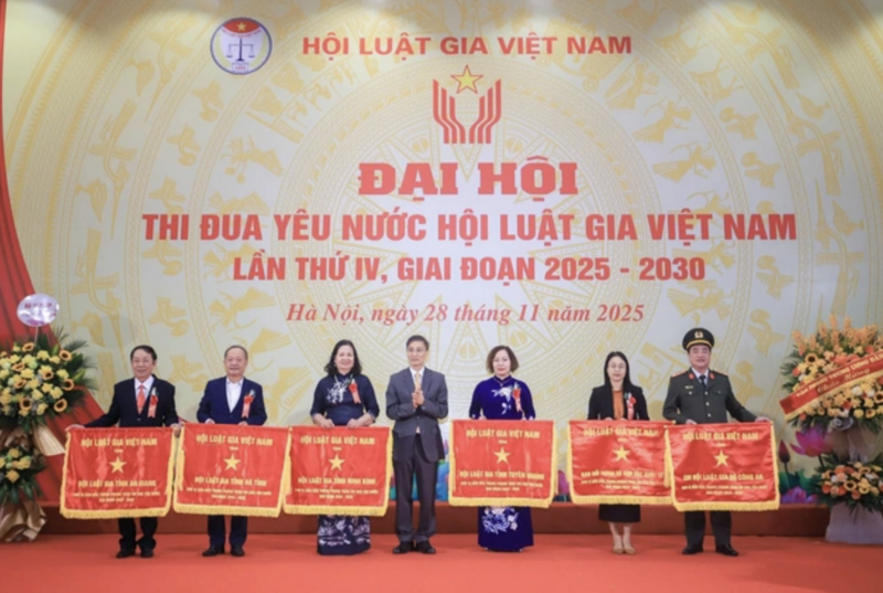 Chủ tịch Hội Luật gia Việt Nam tặng cờ thi đua cho các đơn vị điển hình tiên tiến. Ảnh: NĐT