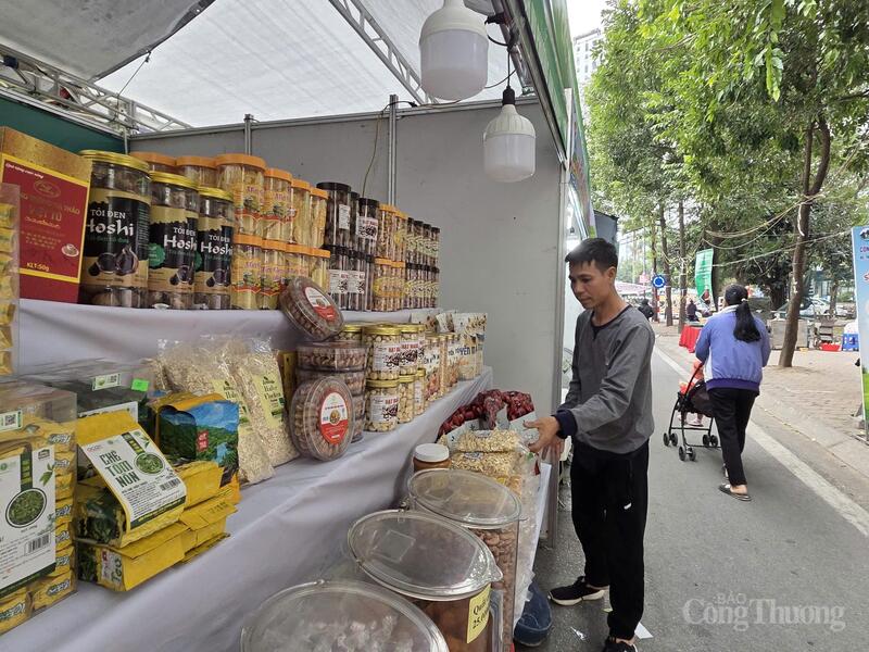 Trần Chung Hiếu, đại diện Công ty TNHH Dịch vụ thương mại Phương Anh chuyên bán thực phẩm ăn liền bày biện gian hàng.