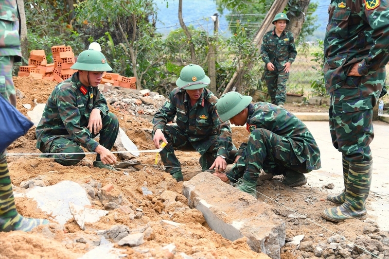 Các cán bộ, chiến sĩ xây dựng nhà cho người dân. Ảnh: Văn Viễn