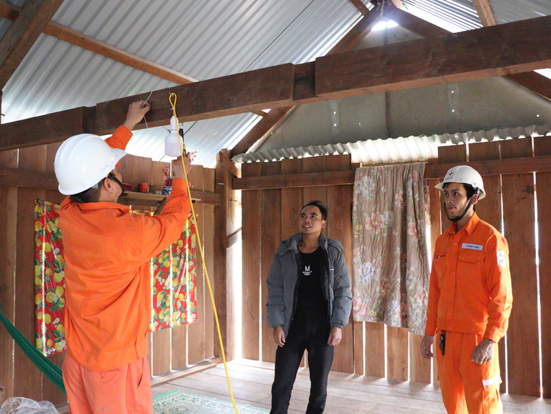 Công nhân lắp đặt bóng đèn và bảng điện mới trong các hộ gia đình.