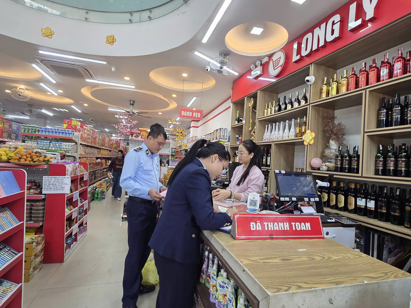 Lực lượng Quản lý thị trường Tuyên Quang, tuyên truyền vận động hộ kinh doanh trên địa bàn ký cam kết chấp hành quy định pháp luật . Ảnh: Văn Thi