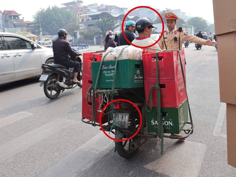 Xử lý tài xế chở hàng cồng kềnh, đội mũ bảo hiểm không cài quai. Ảnh: Công an TP. Hà Nội