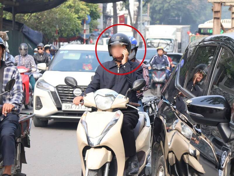 Người điều khiển xe máy sử dụng điện thoại khi tham gia giao thông. Ảnh: Công an TP. Hà Nội