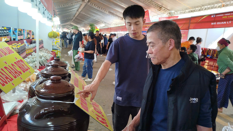 Người dân tìm hiểu công thức sản xuất nước mắm tại hội chợ.