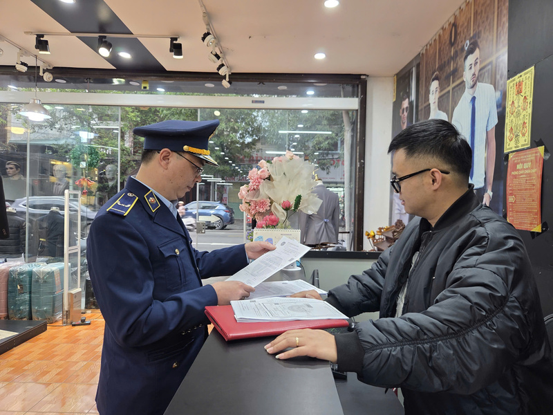 Đội Quản lý thị trường số 6 thực hiện công tác tuyên truyền, vận động các hộ kinh doanh trên địa bàn ký cam kết chấp hành quy định pháp luật trong hoạt động thương mại. Ảnh: Văn Thi