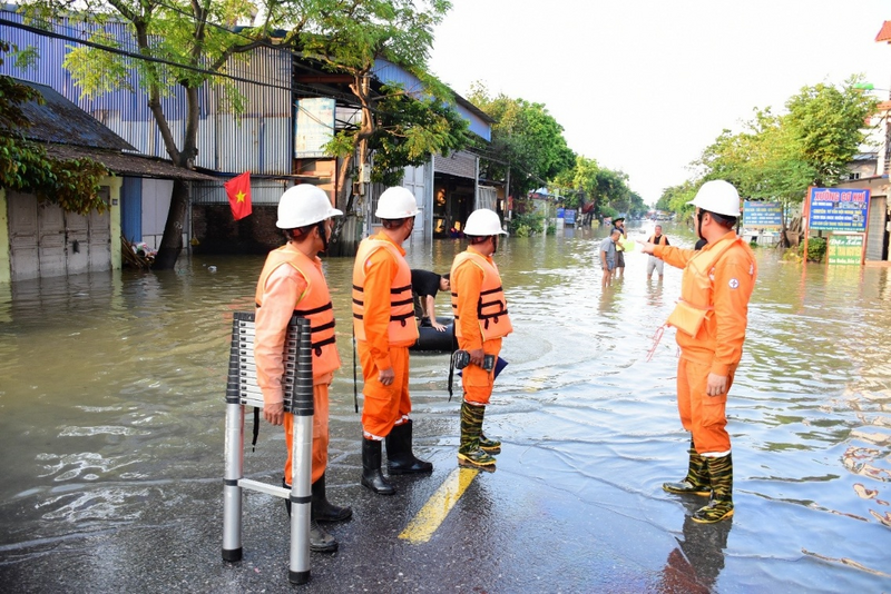 Công nhân EVNHANOI kiểm tra tình trạng lưới điện nơi ngập úng tại khu vực Sóc Sơn