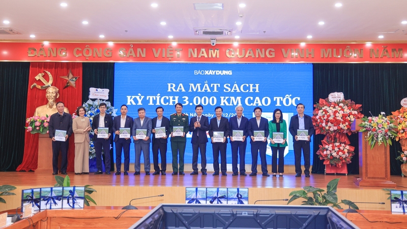 Thứ trưởng Bộ Xây dựng Lê Anh Tuấn và Tổng Biên tập Báo Xây dựng Nguyễn Thị Hồng Nga tặng sách kỷ niệm các khách mời tham dự lễ ra mắt. Ảnh: Tạ Hải