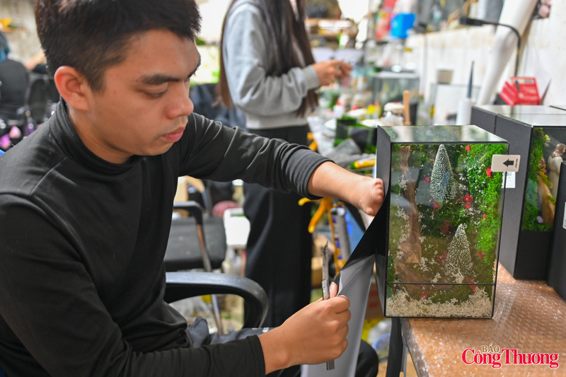 Anh Nguyễn Thế Sơn đang miệt mài với công việc của mình, dù có khó khăn khi một bên tay của anh không được lành lặn.