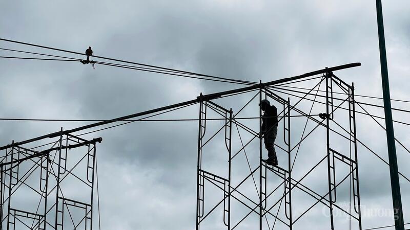 Công nhân leo lên giàn giáo khắc phục sự cố. Ảnh: Lê Sơn