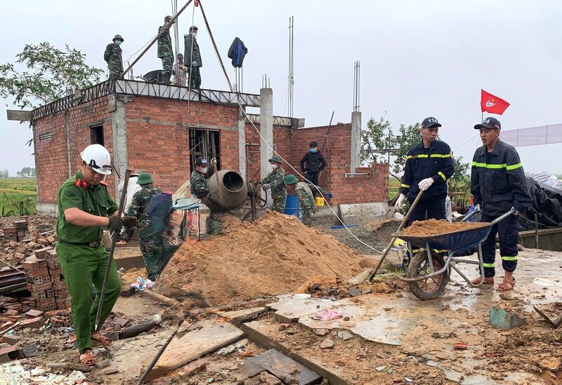 Cán bộ, chiến sĩ Công an tỉnh Đắk Lắk phối hợp với lực lượng tại địa phương xây dựng nhà ở cho người dân vùng lũ. Ảnh: TTXVN