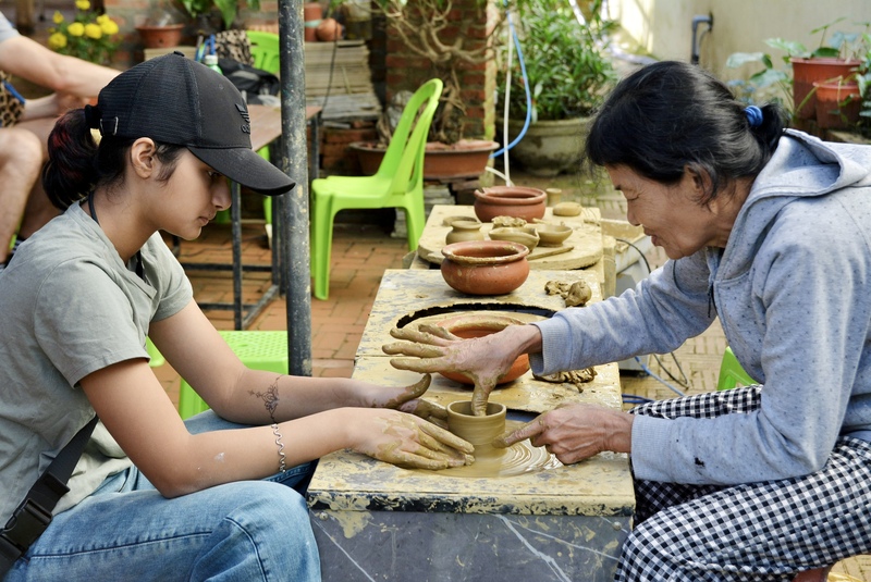 Du khách trải nghiệm nghề làm gốm tại làng gốm Thanh Hà. Ảnh: Ngọc Thảo