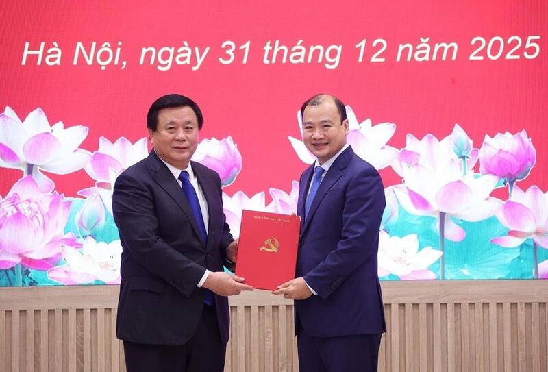 GS.TS Nguyễn Xuân Thắng, Ủy viên Bộ Chính trị, Bí thư Đảng ủy, Giám đốc Học viện Chính trị quốc gia Hồ Chí Minh, Chủ tịch Hội đồng Lý luận Trung ương trao quyết định và tặng hoa chúc mừng ông Lê Hải Bình. Ảnh: TTXVN