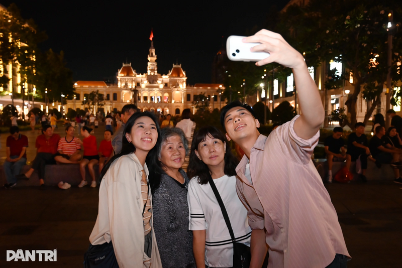 Người dân check-in tại phố đi bộ Nguyễn Huệ trước giờ giao thừa. Ảnh: Dân trí