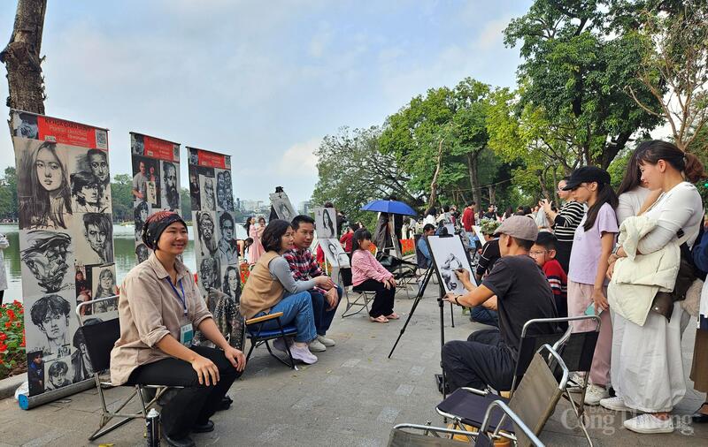 Những họa sỹ vẽ chân dung bên hồ Hoàn Kiếm bận rộn hơn ngày thường. Ảnh: TK