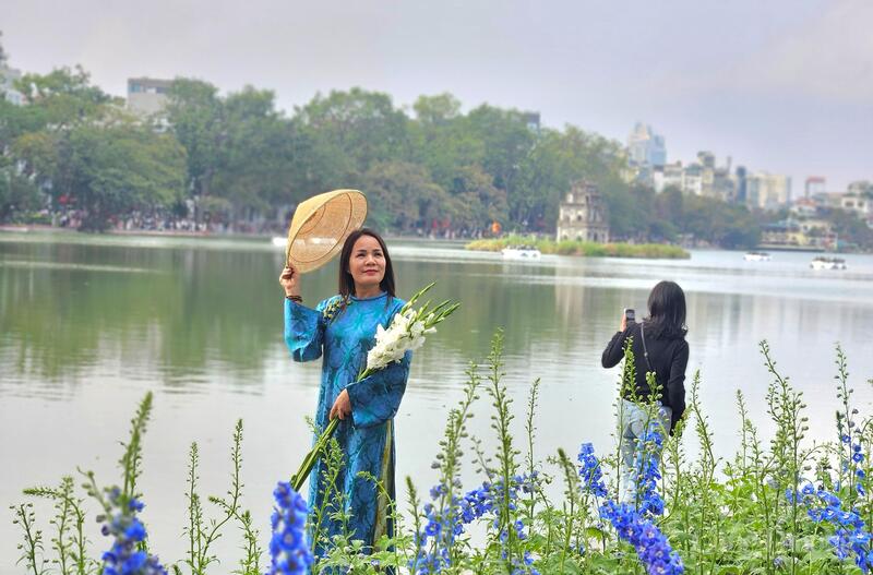 Những chiếc máy ảnh, điện thoại ghi lại khoảnh khắc đẹp bên Tháp Rùa in bóng. Ảnh: TK