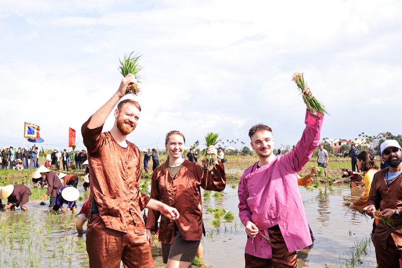 Du khách khoác lên mình bộ bà ba, được trải nghiệm làm công việc nhà nông: từ cày đất, cấy lúa, tát nước đến bắt cá ven bờ… Ảnh: Diễm Phúc