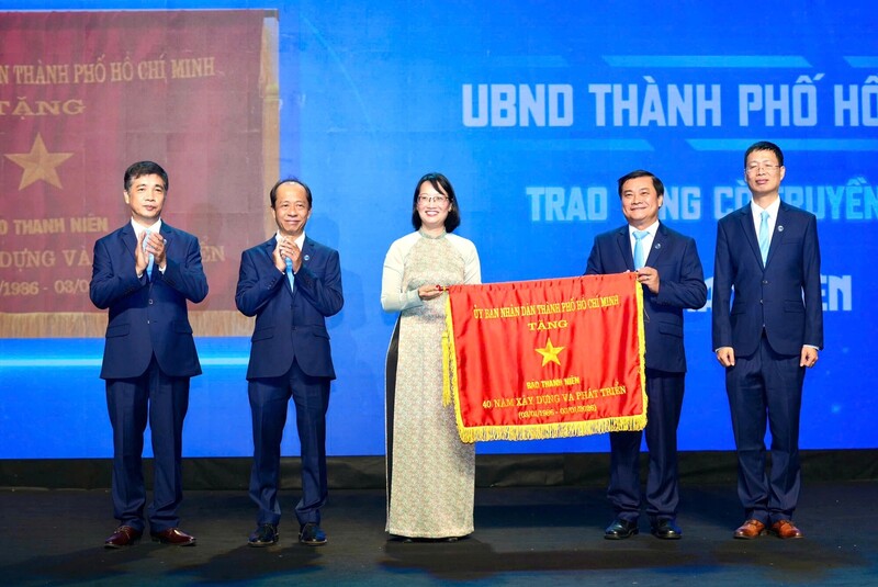 Phó Chủ tịch UBND TPHCM Trần Thị Diệu Thúy tặng Cờ truyền thống của UBND TPHCM cho Báo Thanh Niên. Ảnh: Linh Anh