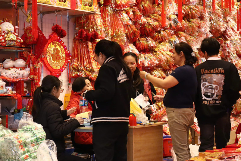 Gắn bó nghề buôn bán trên phố Hàng Mã nhiều năm, chị Đoàn Thanh Thư (áo đỏ) cho biết, thị trường Tết năm nay khởi động sớm nhưng diễn ra chậm rãi hơn thường lệ. Chị chia sẻ: “Không khí Tết đến sớm nhưng sức mua trải đều, không dồn dập như mọi năm do thời gian chuẩn bị Tết kéo dài hơn những năm trước". Chị Phạm Phương Nhung, 23 tuổi (Hải Phòng) cho biết, dịp Tết năm nay, gia đình chị kinh doanh đồ trang trí nên chị trực tiếp lên phố Hàng Mã nhập hàng về bán. Theo chị Nhung, giá năm nay ở mức hợp lý, dễ nhập buôn hơn so với năm trước. Chị nhận định: “Các loại mành, câu đối, khánh chúc mừng năm mới hay tượng thần tài vẫn được nhiều người quan tâm, năm nay khả năng vẫn bán tốt”.Cùng với đồ trang trí, các loại hộp đựng quà Tết cũng phong phú về mẫu mã, được bán với mức giá từ 70.000 đến 150.000 đồng.Ảnh: Phương Hà