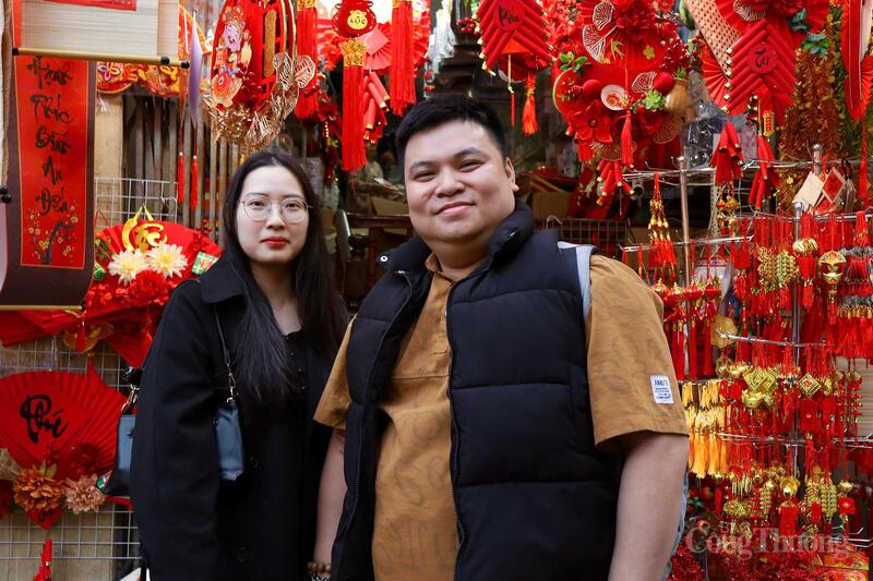 Anh Nguyễn Tiến Dũng (30 tuổi, Thái Nguyên) và chị Vũ Kim Xuyến (26 tuổi, Ninh Bình) cùng dạo phố, chụp ảnh và tận hưởng không khí Xuân sớm. Gắn bó nghề buôn bán trên phố Hàng Mã nhiều năm, chị Đoàn Thanh Thư (áo đỏ) cho biết, thị trường Tết năm nay khởi động sớm nhưng diễn ra chậm rãi hơn thường lệ. Chị chia sẻ: “Không khí Tết đến sớm nhưng sức mua trải đều, không dồn dập như mọi năm do thời gian chuẩn bị Tết kéo dài hơn những năm trước". Chị Phạm Phương Nhung, 23 tuổi (Hải Phòng) cho biết, dịp Tết năm nay, gia đình chị kinh doanh đồ trang trí nên chị trực tiếp lên phố Hàng Mã nhập hàng về bán. Theo chị Nhung, giá năm nay ở mức hợp lý, dễ nhập buôn hơn so với năm trước. Chị nhận định: “Các loại mành, câu đối, khánh chúc mừng năm mới hay tượng thần tài vẫn được nhiều người quan tâm, năm nay khả năng vẫn bán tốt”.Cùng với đồ trang trí, các loại hộp đựng quà Tết cũng phong phú về mẫu mã, được bán với mức giá từ 70.000 đến 150.000 đồng.Ảnh: Phương Hà