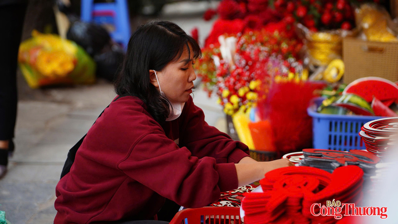 Chị Hoàng Anh đang tất bật sắp xếp lại kệ hàng của mình. Ảnh: Thái Mạnh