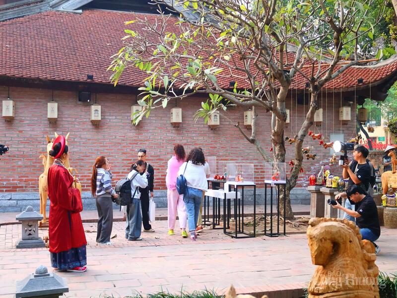 Nhiều du khách tham quan, trong đó có cả khách nước ngoài, tỏ ra thích thú và hào hứng chụp ảnh lưu niệm bên những sản phẩm ngựa gỗ được trưng bày.