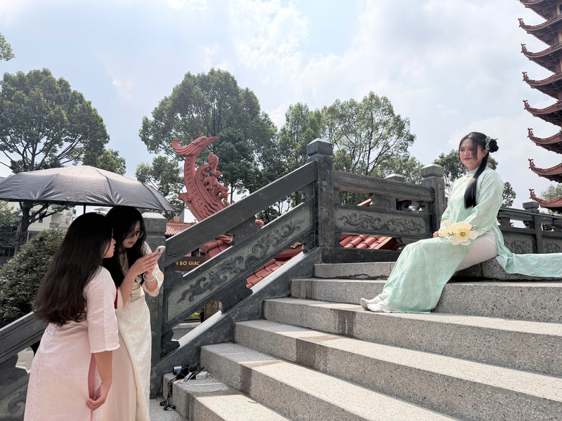 Các bạn trẻ tỉ mỉ chỉnh sửa trang phục, góc máy để có bức hình ưng ý nhất. Ảnh: Minh Anh