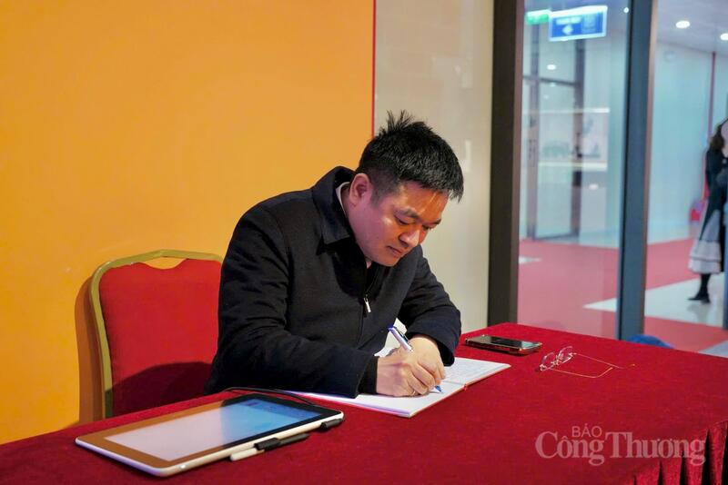 Đồng chí Nguyễn Văn Minh viết lưu bút ghi dấu cảm xúc và trách nhiệm của người làm báo Báo Công Thương tại Triển lãm Đại hội XIV của Đảng