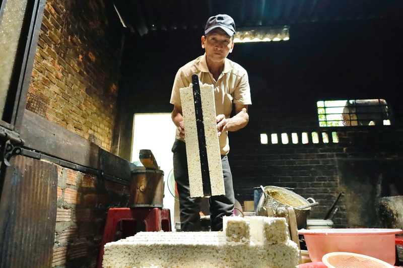 Bánh được ép chặt thành một khối liên kết rồi sau đó mới cắt thành từng miếng. Ảnh: Nguyễn Dương