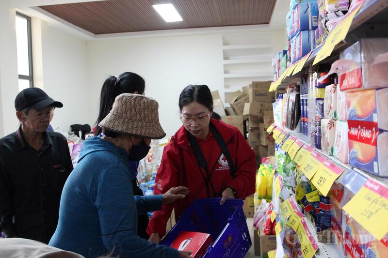 Bà Huỳnh Thị Chín (áo xanh) lựa chọn các sản phẩm tiêu dùng thiết yếu cho gia đình.