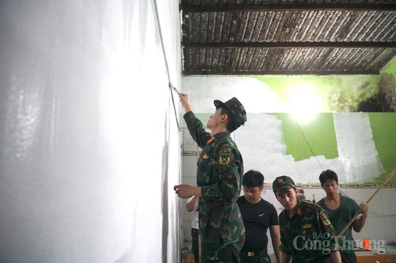 Những bức tường nấm mốc và đã bị phai màu sơn của gia đình chị Kiều lần lượt được các cán bộ chiến sĩ thay mới sáng bóng, tinh tươm