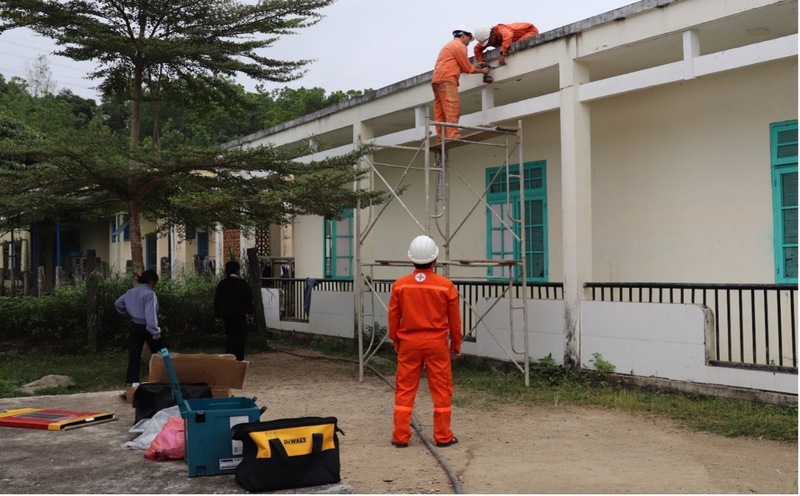 Cán bộ nhân viên công ty thực hiện việc lắp mới các bóng đèn tại trường Phổ thông Dân tộc Bán trú Trung học cơ sở Nam Giang. Ảnh: Văn Tuấn