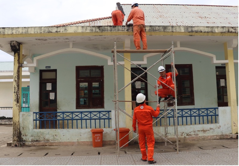 Thực hiện việc lắp mới các bóng đèn tại trường Phổ thông Dân tộc Bán trú Trung học cơ sở Bến Giằng. Ảnh: Văn Tuấn