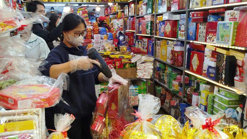 Nhân viên tại một của hàng tạp hóa ở chợ Nghĩa Tân tất bật đóng gói giỏ quà Tết