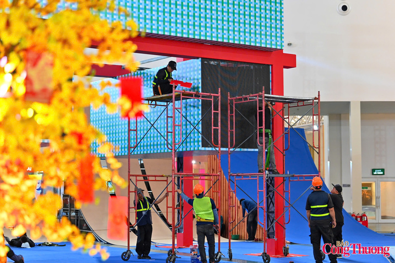 Nhịp lao động liên tục tại khu trưng bày, thể hiện tinh thần trách nhiệm và sự phối hợp chặt chẽ giữa các lực lượng trước thời khắc khai mạc. Ảnh: Nam Nguyễn.