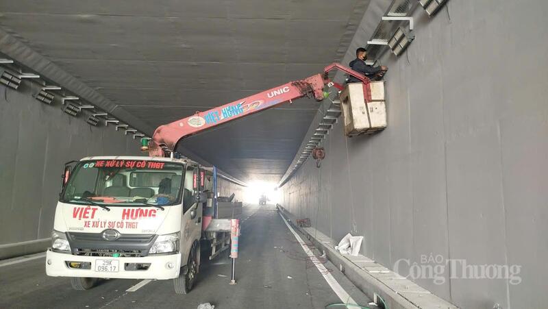 Công nhân đang hoàn thiện lắp đặt hệ thống đèn điện chiếu sáng trong hầm chui.