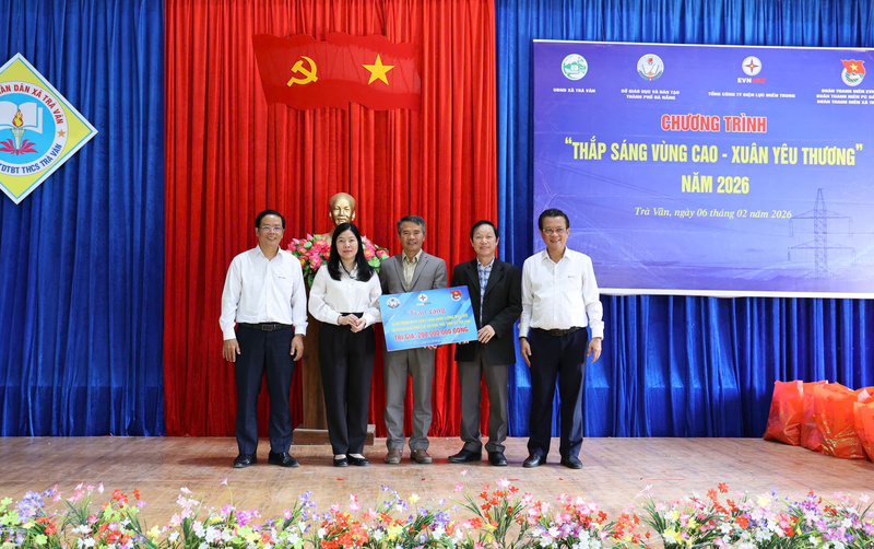 Trao bảng tượng trưng tặng 30 hệ thống chiếu sáng điện năng lượng mặt trời và các phần quà cho các hộ nghèo, học sinh trên địa bàn xã miền núi Trà Vân. Ảnh: Phương Nam