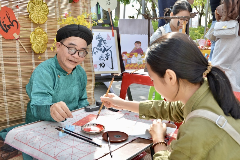 Phiên chợ tổ chức đồng thời hoạt động viết thư pháp và vẽ kí hoạ, thể hiện sự giao thoa giữa nét truyền thống và hiện đại. Ảnh: Ngọc Thảo