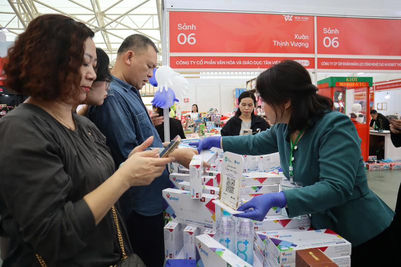 Bà Phùng Mai Lan, Phó Giám đốc Công ty TNHH Thương mại Quốc tế Vtech (bên phải) giới thiệu chi tiết công dụng của những chiếc găng tay tới người tiêu dùng. Ảnh: H.Q