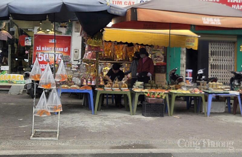 Cá chép đỏ được bày bán xen kẽ với đồ lễ vàng mã tại khu vực chợ dân sinh, phục vụ nhu cầu cúng ông Công ông Táo của người dân trong những ngày cận 23 tháng Chạp.