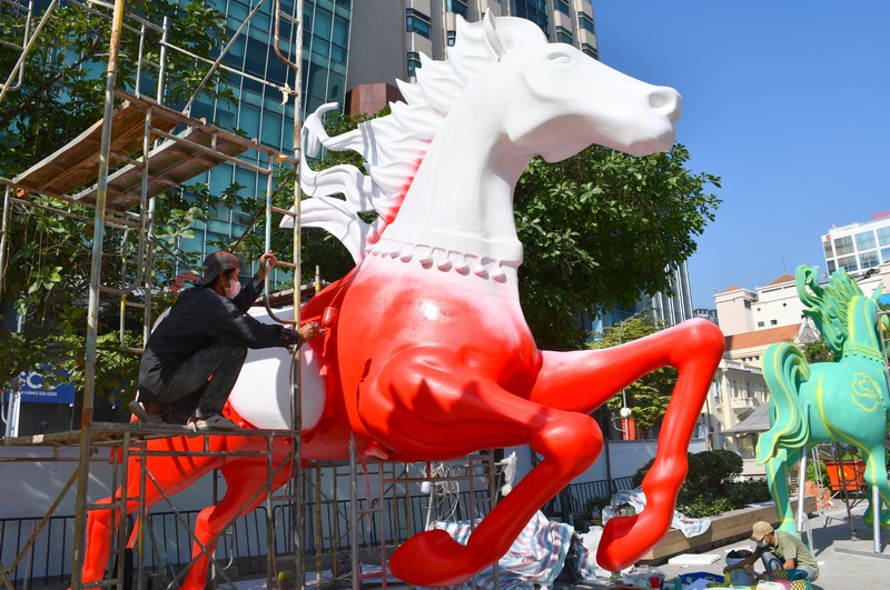 Công nhân phun sơn, hoàn thiện tạo hình tượng linh ngựa tại cuối đường hoa Nguyễn Huệ xuân Bính Ngọ 2026 - khu vực phía sông Bạch Đằng. Ảnh: Thanh Minh.